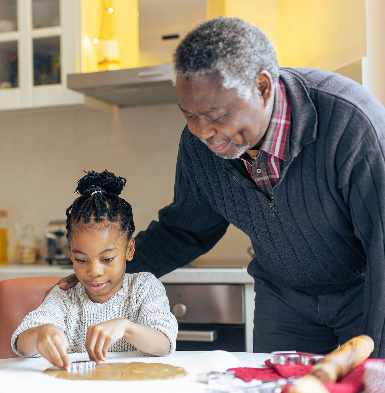 Grampa helping is grandchild make cookies